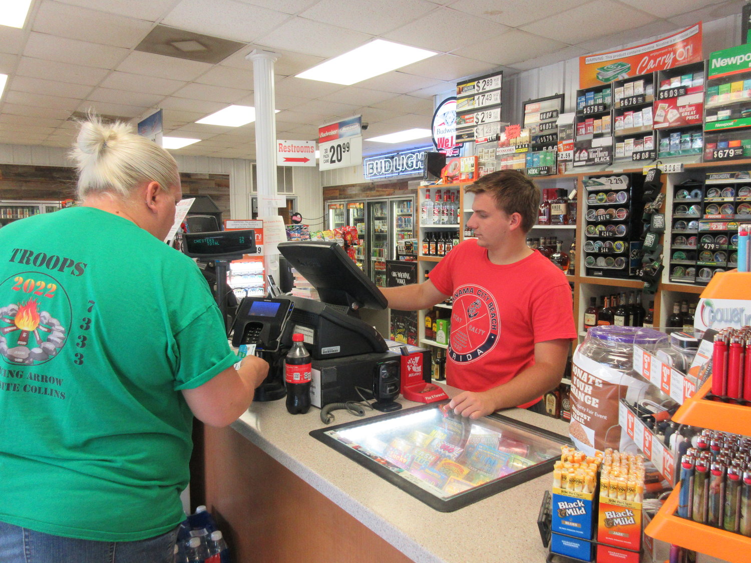 Vienna Quik Spot worker, Caleb Horman, assists a customer with her purchase.